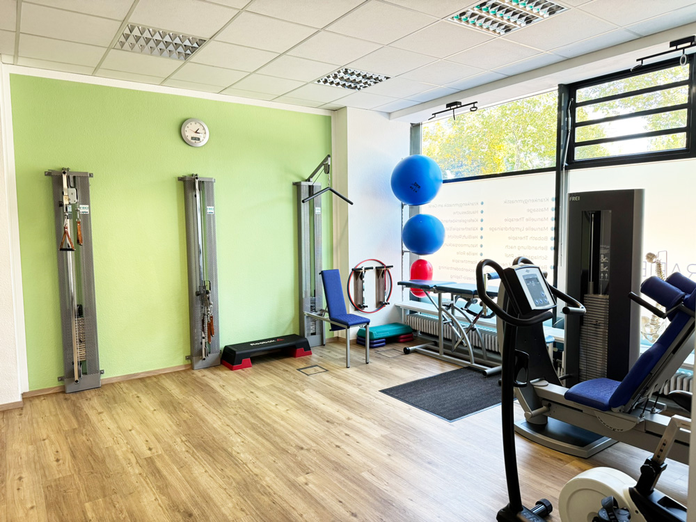 Blick in den hellen Trainingsraum der Physiotherapie Dennis Mann in Mannheim mit modernen Geräten für Therapie und Rehabilitation.