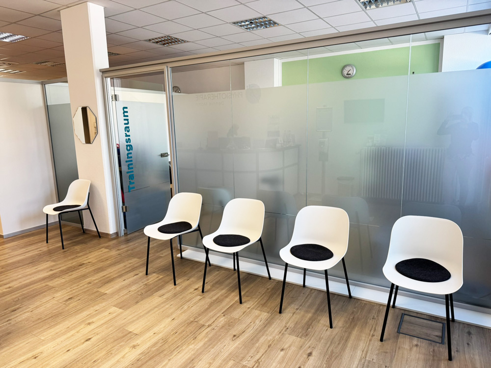 Heller und moderner Wartebereich mit bequemen Sitzgelegenheiten in der Physiotherapie Dennis Mann am Rheingoldplatz in Mannheim.
